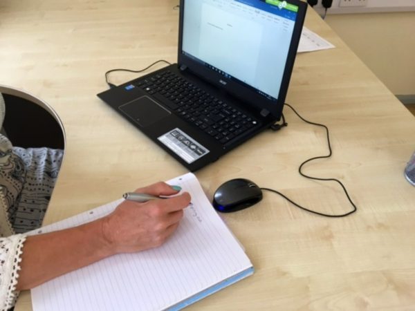 Hand Holding a Pen on Pad of Paper